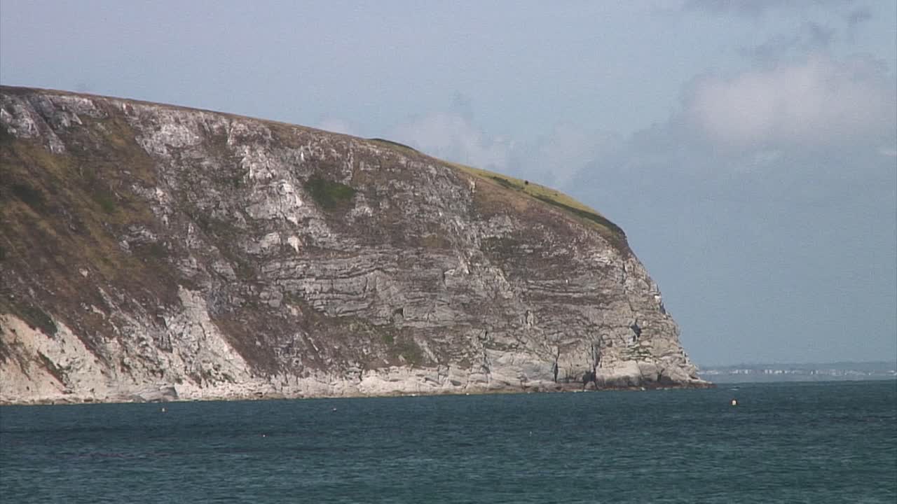 белые меловые скалы, поднимающиеся из океана на морском курорте в бухте суонэйдж в английском графстве дорсет