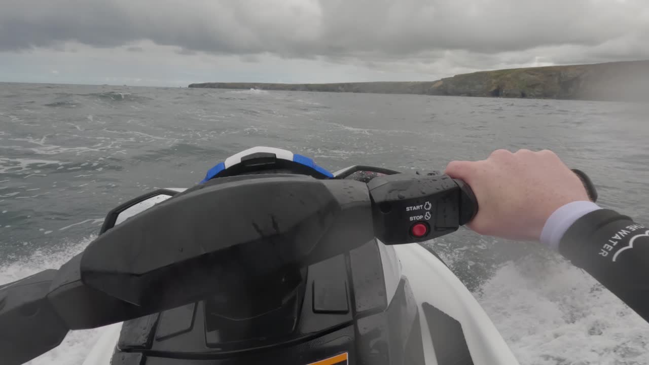 Ripresa POV di un pilota di jet ski che sfreccia su un mare mosso, venendo schizzato.