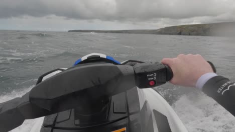 pov shot of a jet ski rider racing across a choppy sea getting splashed