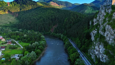flight over the mountain river near the rocks with castle ruins on top. village locates in the valley on the waterfront. tatra mountains in slovakia