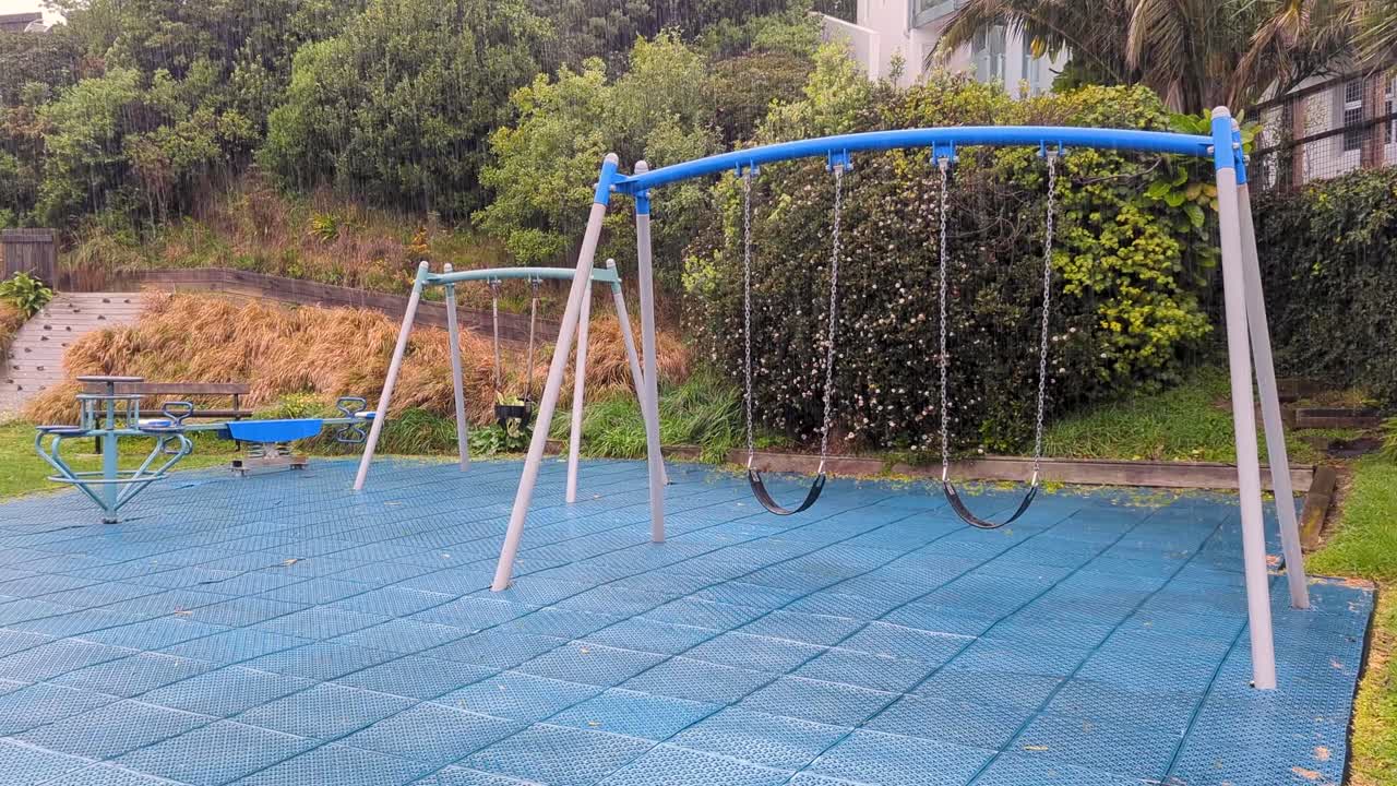 은 비가 내리는 방울의 날씨 조건에서 흔들림과 함께 빈 어린이 놀이터