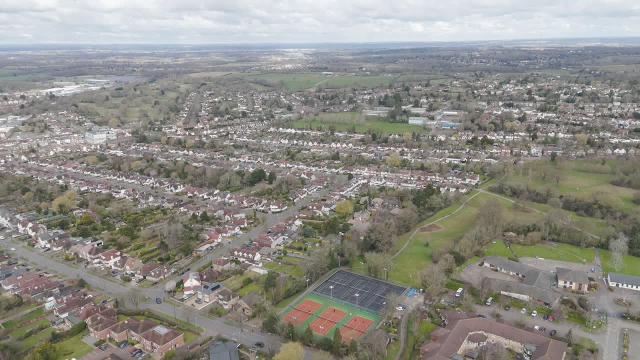 Top-down view of orderly Potters Bar suburb with semi-detached red-roof homes, schools, sports fields and tree-lined avenues illustrating planned commuter-belt living