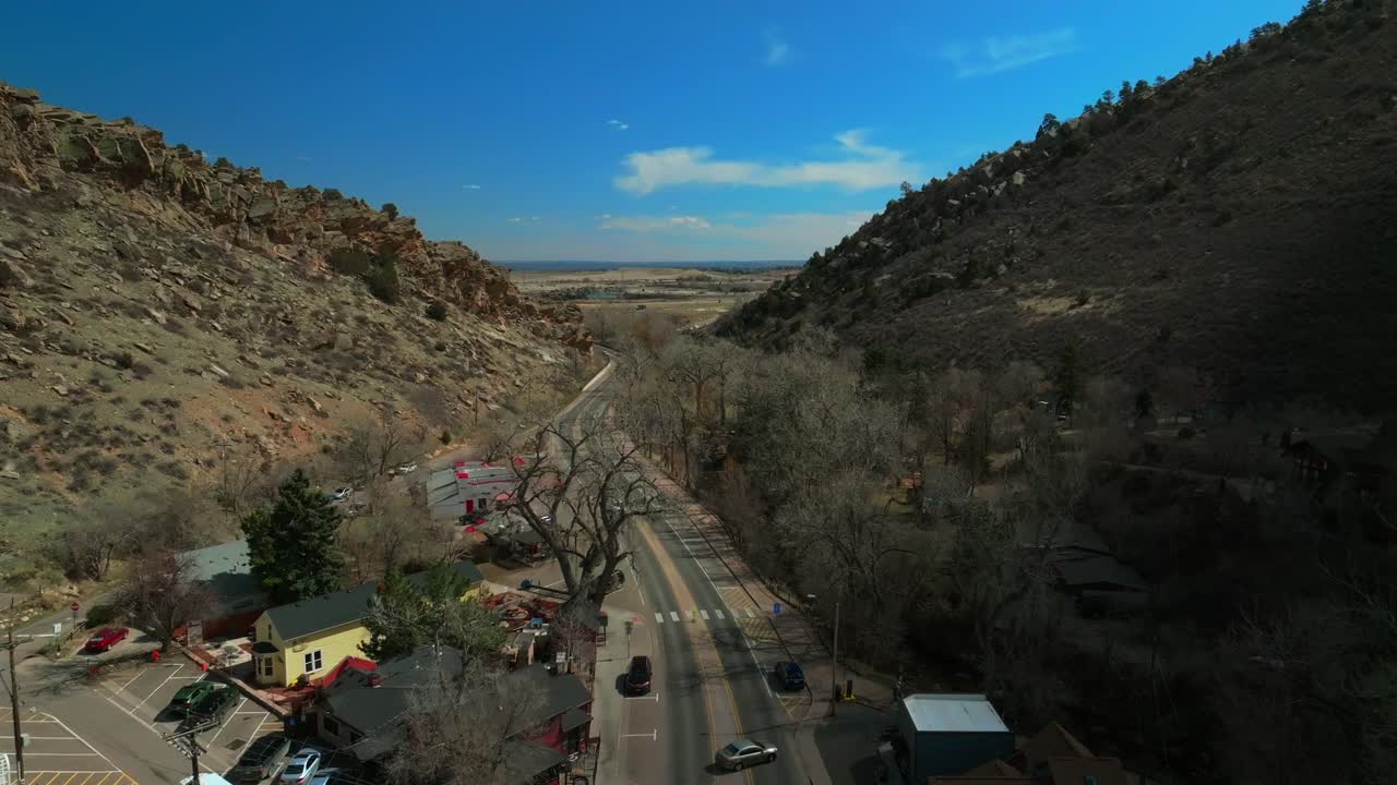Morrison Colorado aerial drone Red Rocks Park and Amphitheater Mount Morrison Bear Creek trail front range Denver sunny blue sky high clouds traffic car driving upward motion