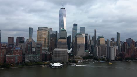 Aerial-view-panning-away-from-the-Battery-park-city-skyline-in-Manhattan,-gloomy-New-York,-USA---pull-back,-drone-shot