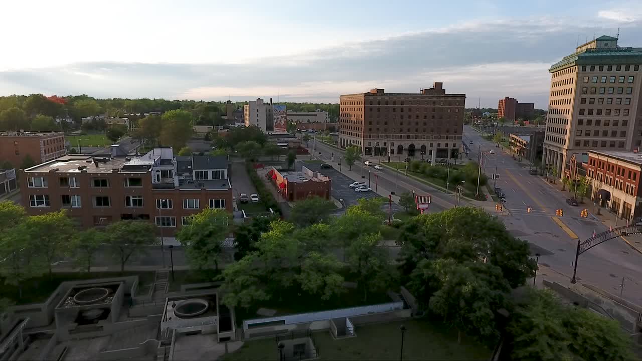 미시간 주 플린트의 사우스 새기노 거리 위로 드론이 날아다니며 해질 무렵 차량 도시 표지판 위로 날아갑니다.