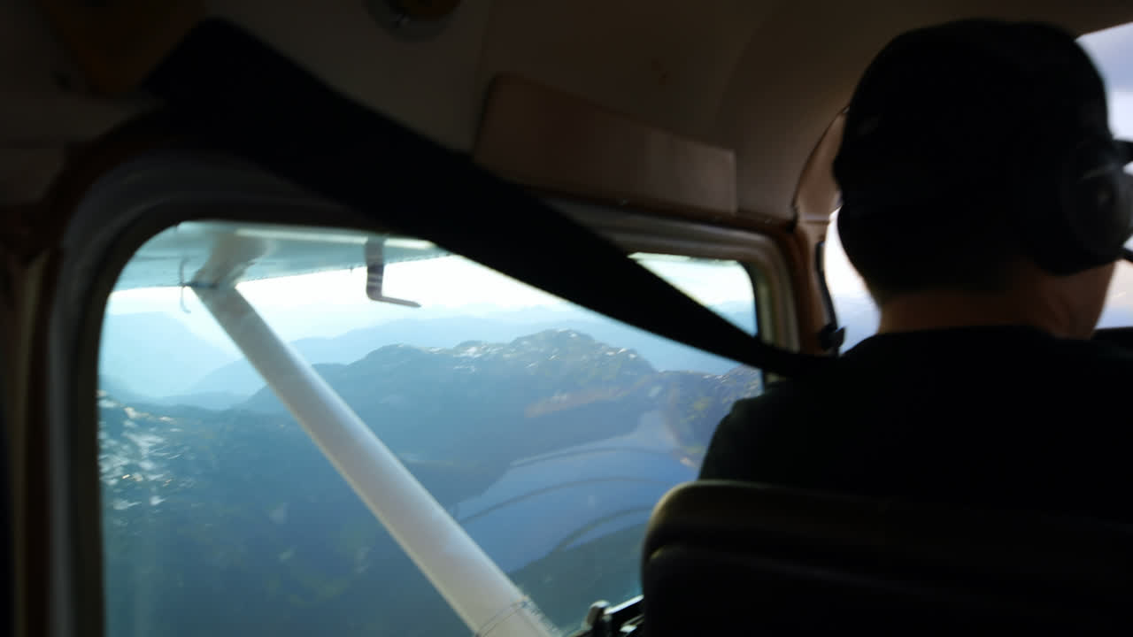piloto volando un avión sobre una montaña cubierta de nieve 4k