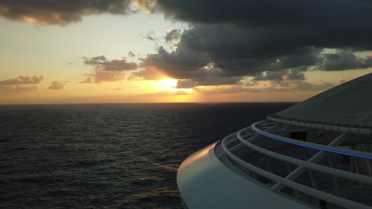 바다를 항해하는 유람선에서 탁 트인 바다 위로 화려한 주황색과 붉은 석양