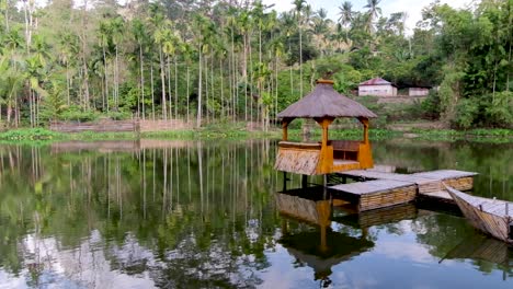 Idyllischer-Bambushüttenponton-Mit-Traditionellem-Strohdach-Auf-Dem-Wasser,-Umgeben-Von-Bäumen-In-Timor-Leste,-Südostasien