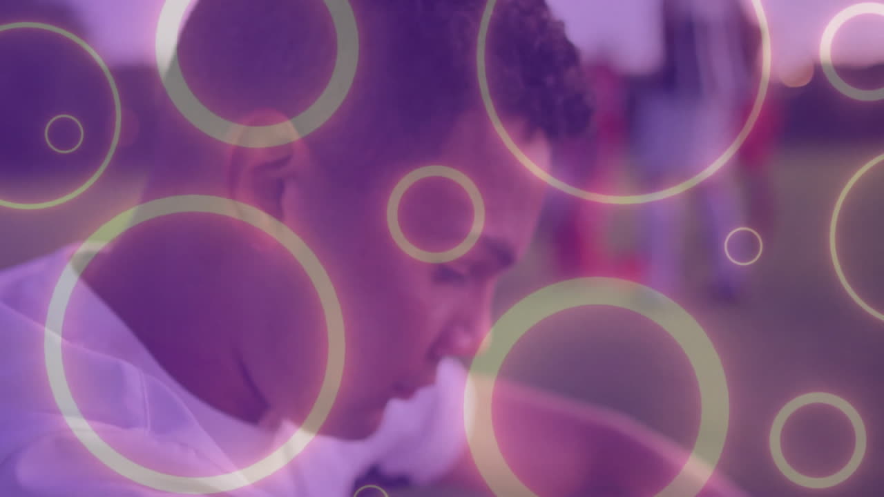 male soccer player focusing on ball on field at dusk, showing sports marketing circular overlays