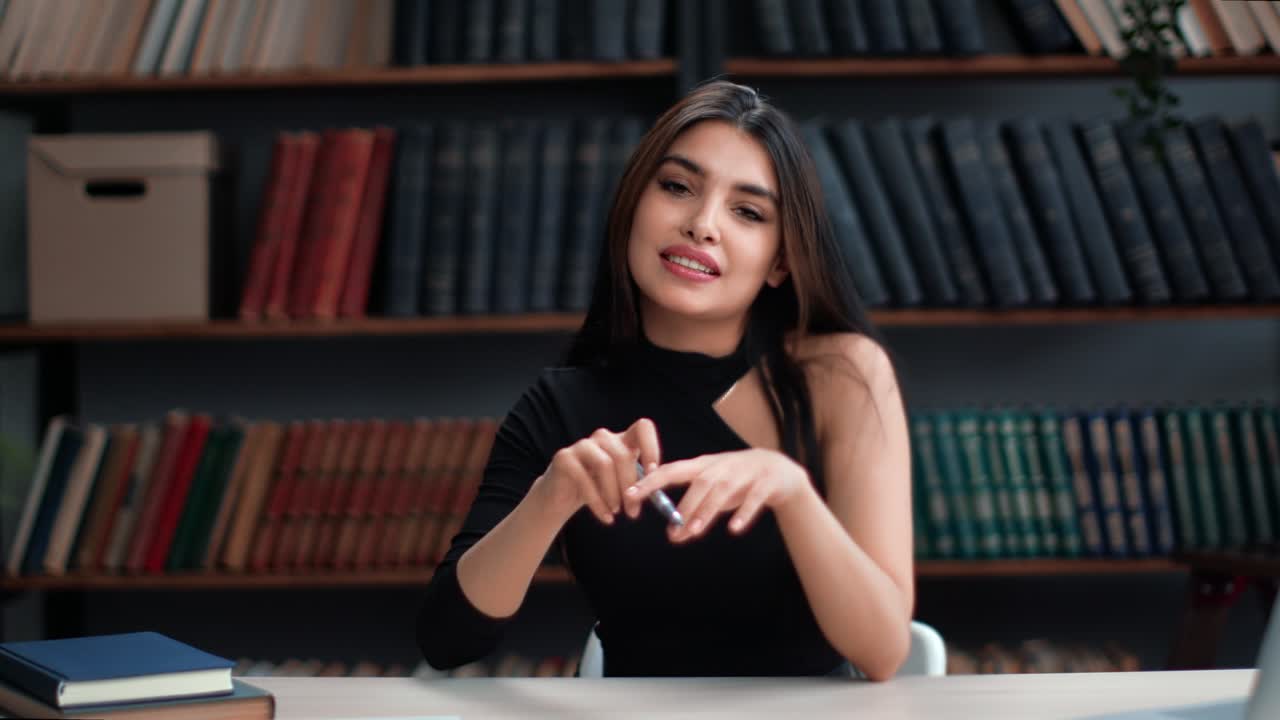 Portrait smiling brunette woman blogger influencer teacher talking webinar at library workplace