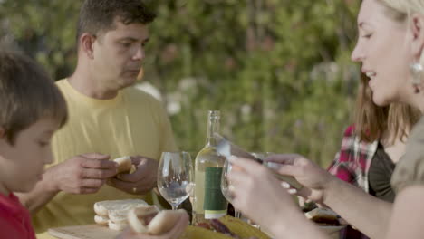 familia feliz con dos hijos almorzando al aire libre