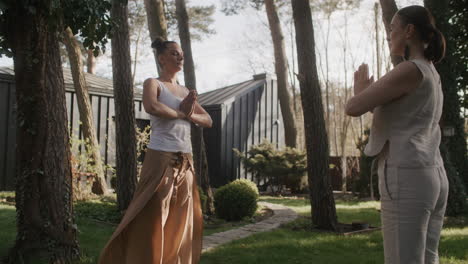 two women practicing yoga in a beautiful garden