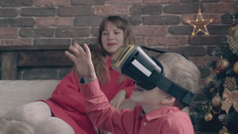 small-boy-uses-virtual-reality-glasses-and-mom-watches