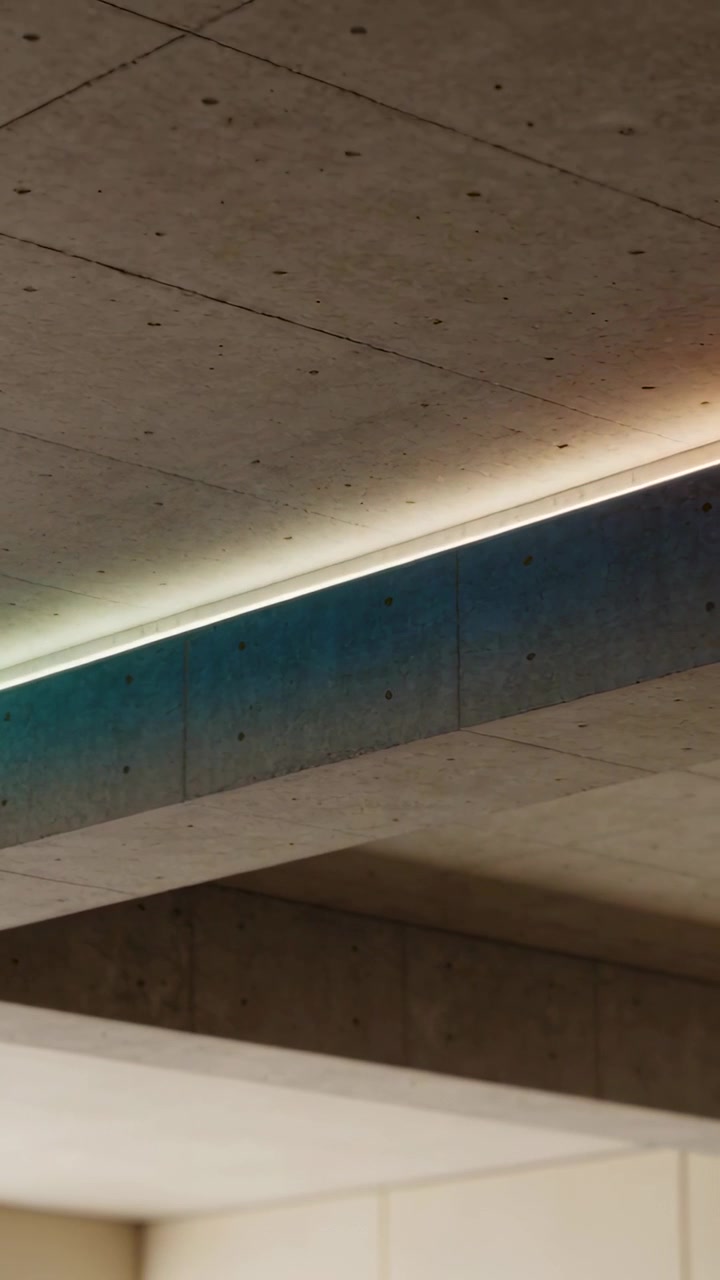 Vertical video: Tilting camera showing diagonal concrete beam and LED seam in hall, shifting color