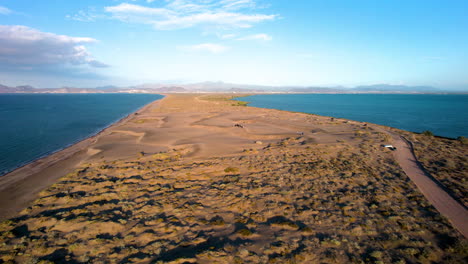 toma orbital de drones del camino de tierra que conduce al área de sandboarding en las dunas de mogote en baja california sur mexico