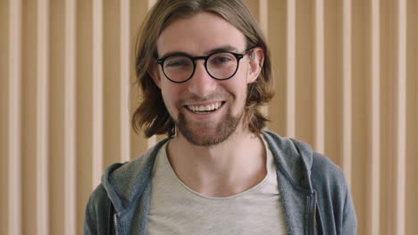 close up portrait of cute geeky man wearing glasses laughing cheerful running hands through hair enjoying success lifestyle relaxed attractive male indoors