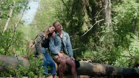 couple relaxing in a forest on a log