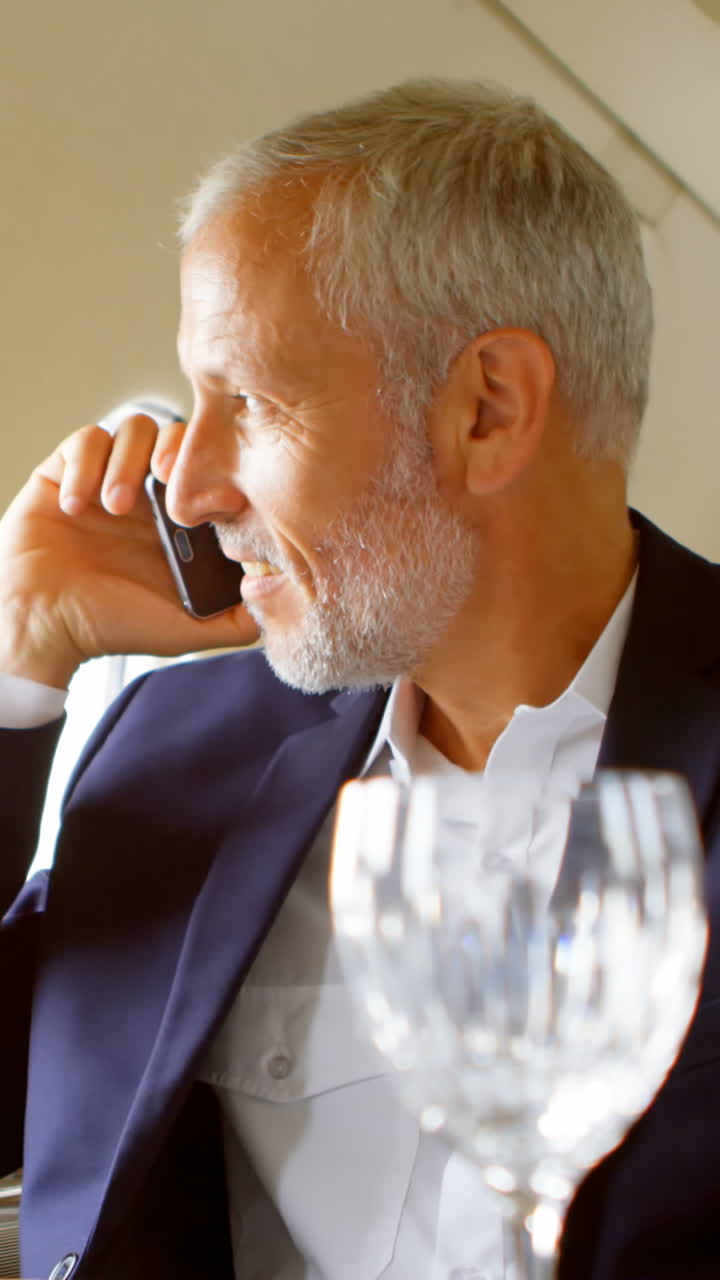 Uomo d'affari che parla al cellulare mentre viaggia su un jet privato 4k