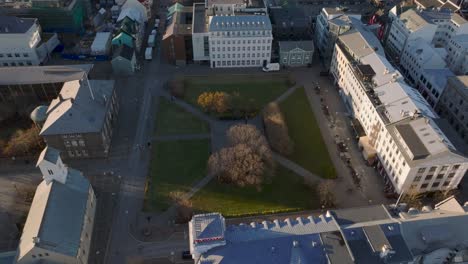 parque austurvöllur en el centro de la ciudad de reykjavik durante la puesta de sol, aérea