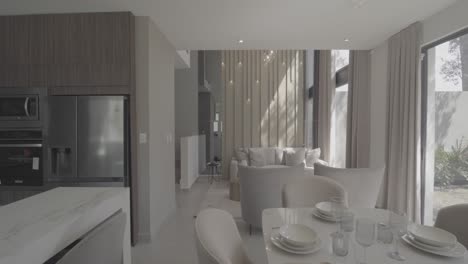 aerial dolly shot of a modern open plan kitchen with dining table set