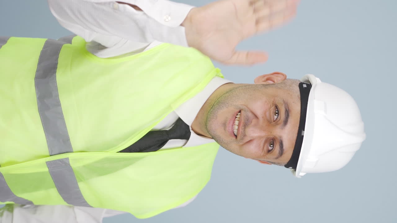 엔지니어가 카메라를 향해 손을 흔들고 있는 수직 비디오