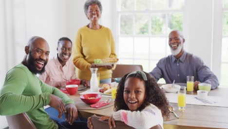 Video-portrait-of-happy-african-american-parents,-daughter-and-grandparents-at-dining-table