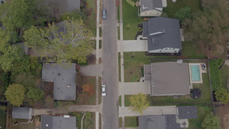 overhead view of a suburban neighborhood in autumn with a push up the street