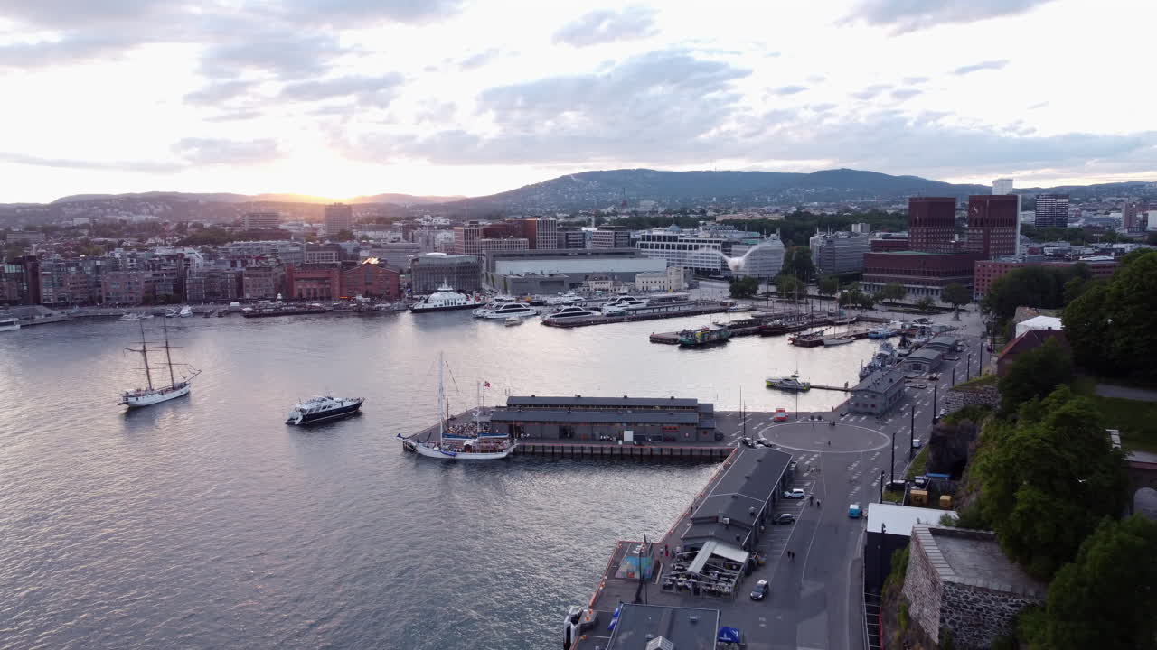 Gaviota curiosa interceptando un dron que filma el paisaje urbano de Oslo durante la hora dorada