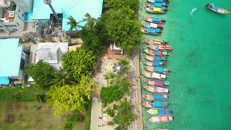 Barcos-Tradicionales-De-Cola-Larga-Anclados-En-El-Puerto,-Isla-De-Koh-Phi-Phi-Don,-Tailandia,-Antena-De-Arriba-Hacia-Abajo