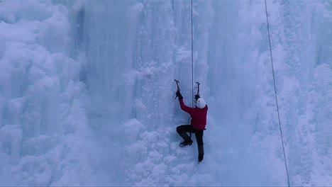 a man climbing a frozen waterfall