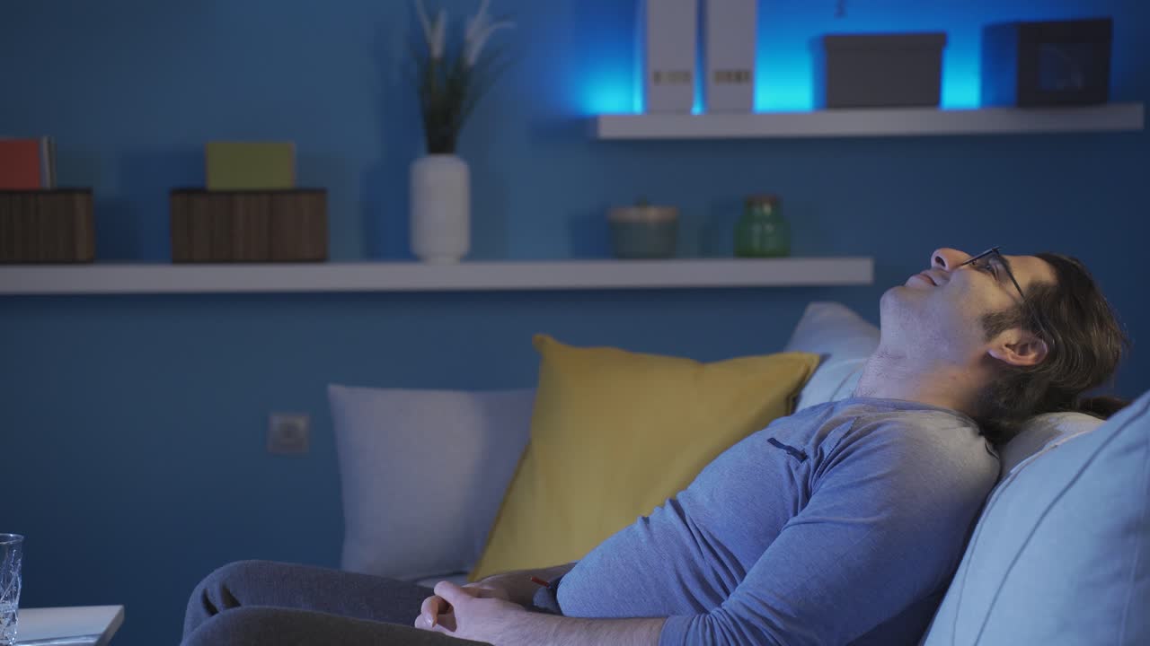 un joven soñando despierto en casa. noche.