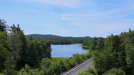 drone shot of the adirondack forest revealing a railroad