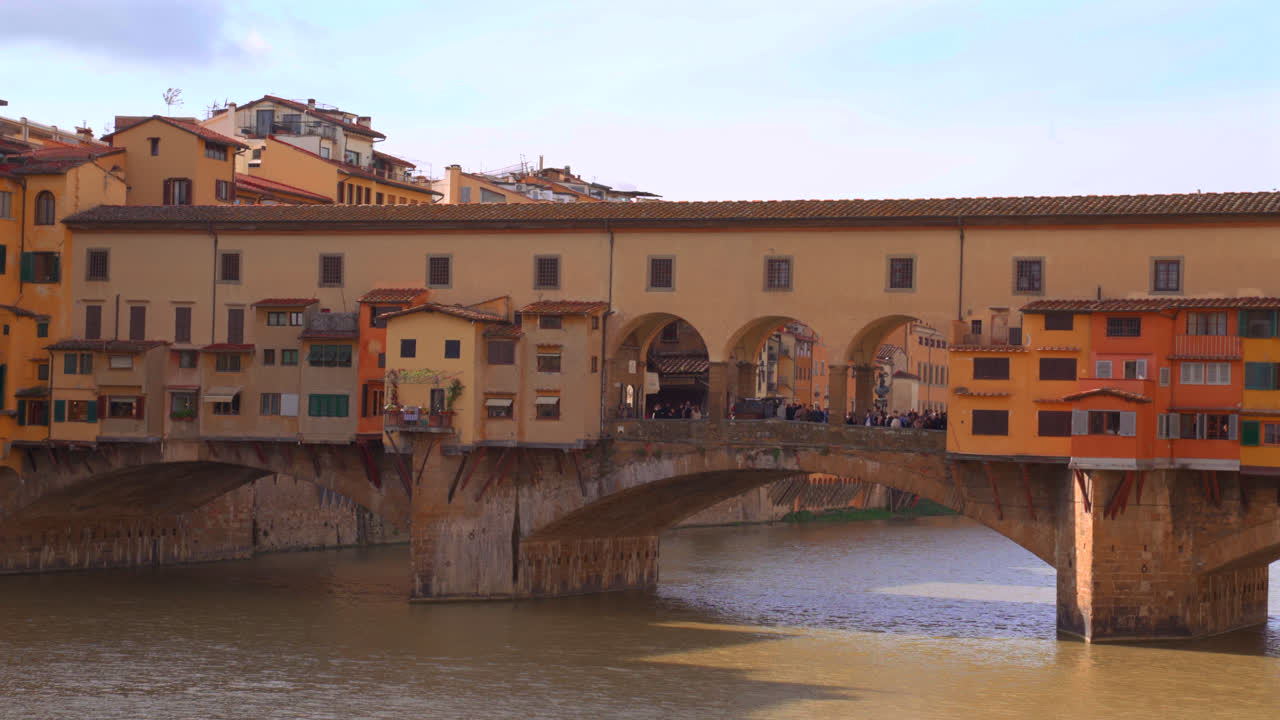 Bridge arno river in Florence with pastel reflections and italian renaissance buildings along bank