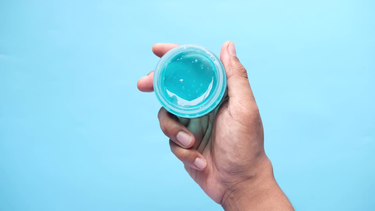 mano sosteniendo un recipiente de gel azul