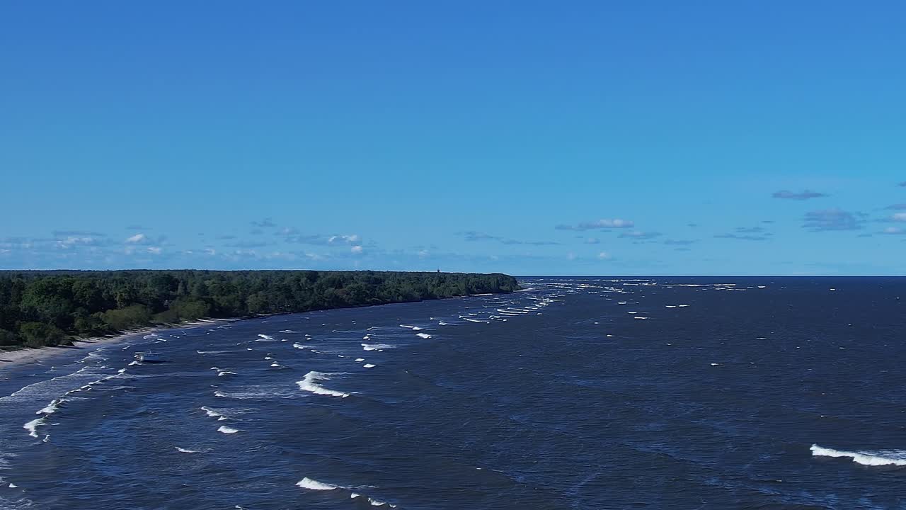 View of Baltic Sea with waves and shoreline under a clear sky