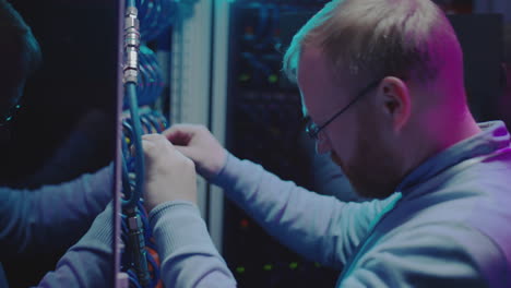 it technician working on server racks in a data center