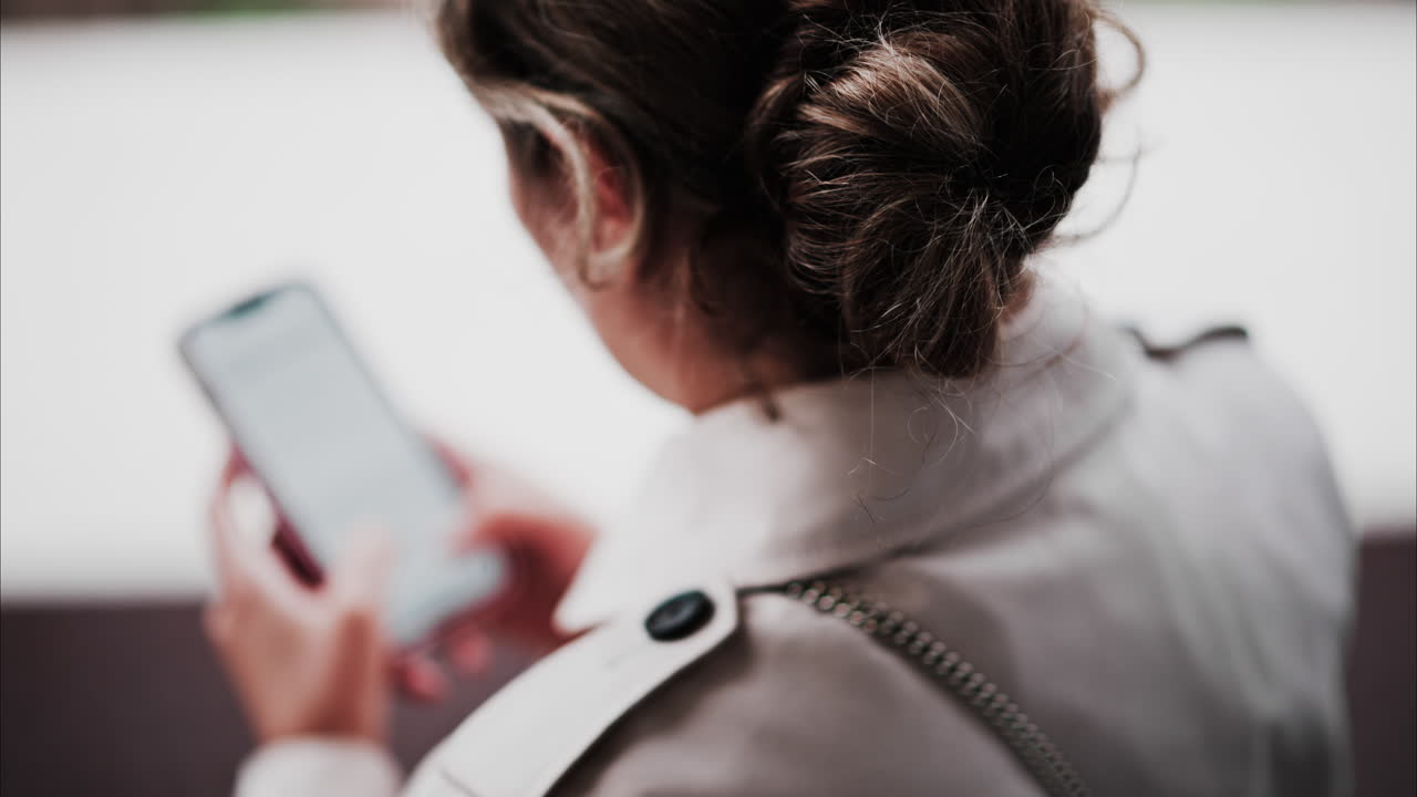 Blurry view of a brunette woman typing on her phone