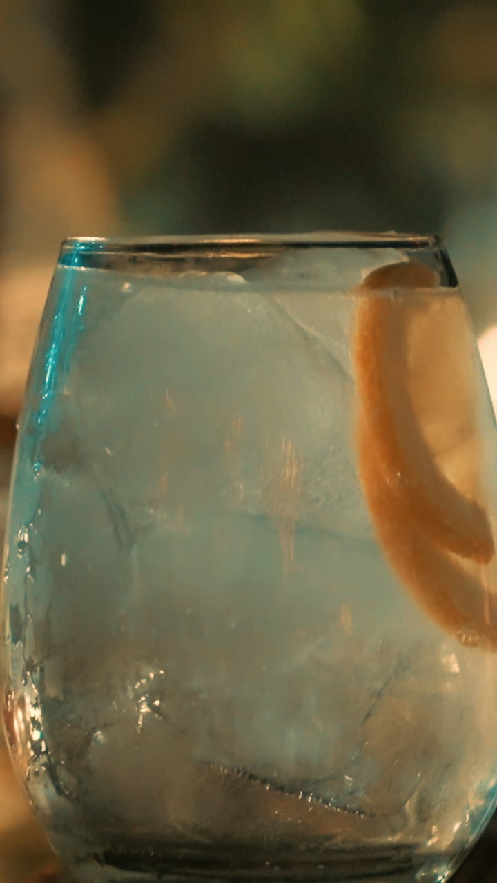 Bevanda rinfrescante con limone e ghiaccio che viene mescolata.