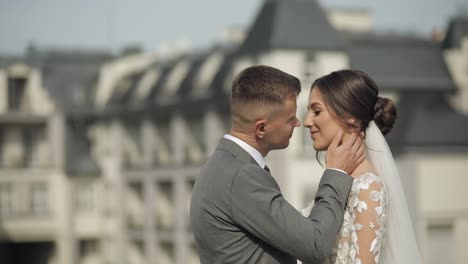 Lovely-newlyweds-caucasian-bride-embracing-groom-making-kiss,-wedding-couple-family-hugging-together