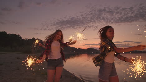 group of friends having fun running on the beach with sparklers