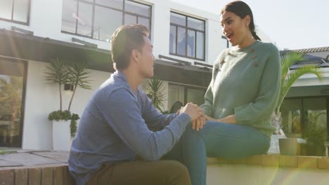 video de una feliz pareja diversa hablando y abrazándose en el jardín