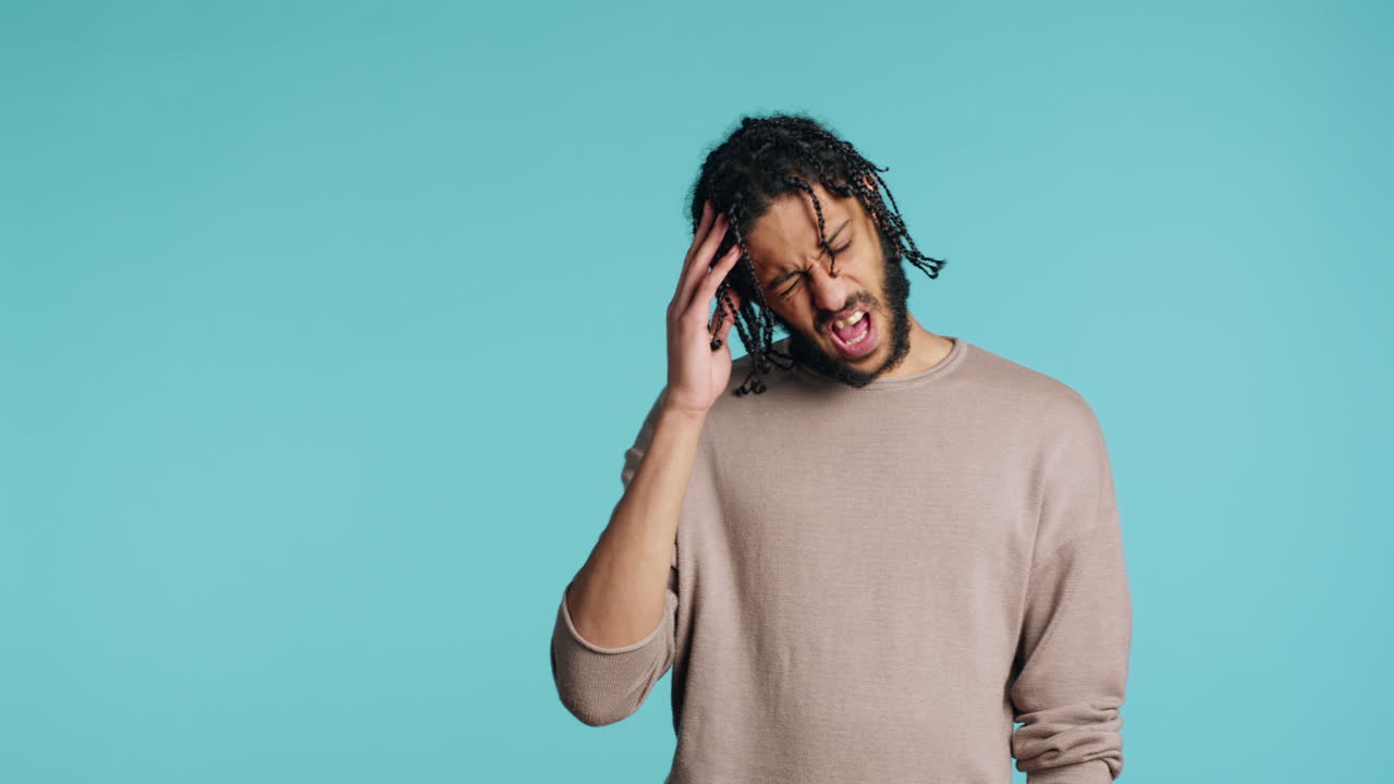 hombre estremecido por el dolor, sufriendo de dolor de cabeza, fondo de estudio