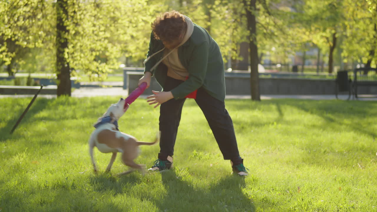Man Playing with Dog in a Sunny Park