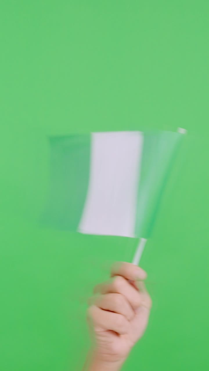Hand waving a pennant of a nigerian national flag