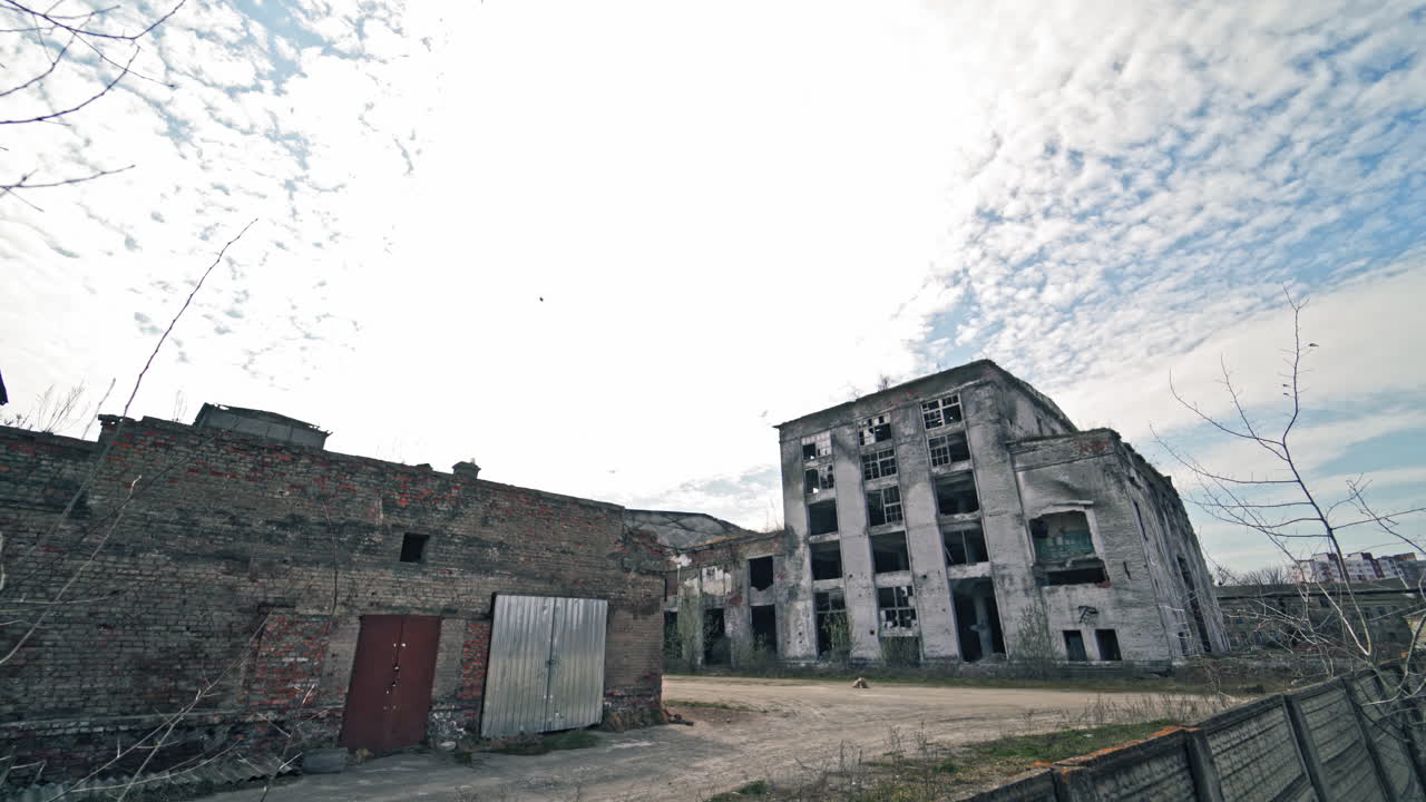 Desolate place with ruined empty buildings outdoors. Gray abandoned buildings without windows after military actions.