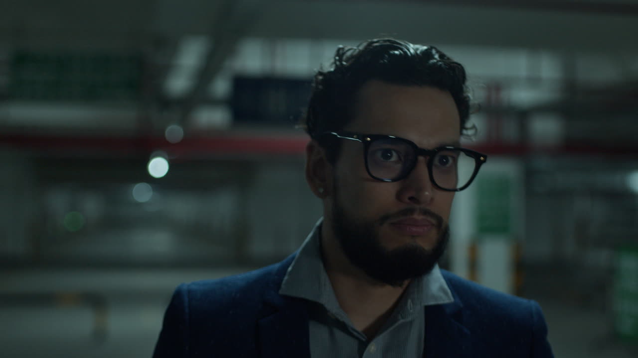 Uomo in un parcheggio di notte