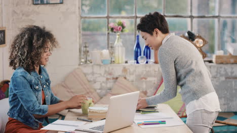 diverse group of students studying at home using books and laptop technology