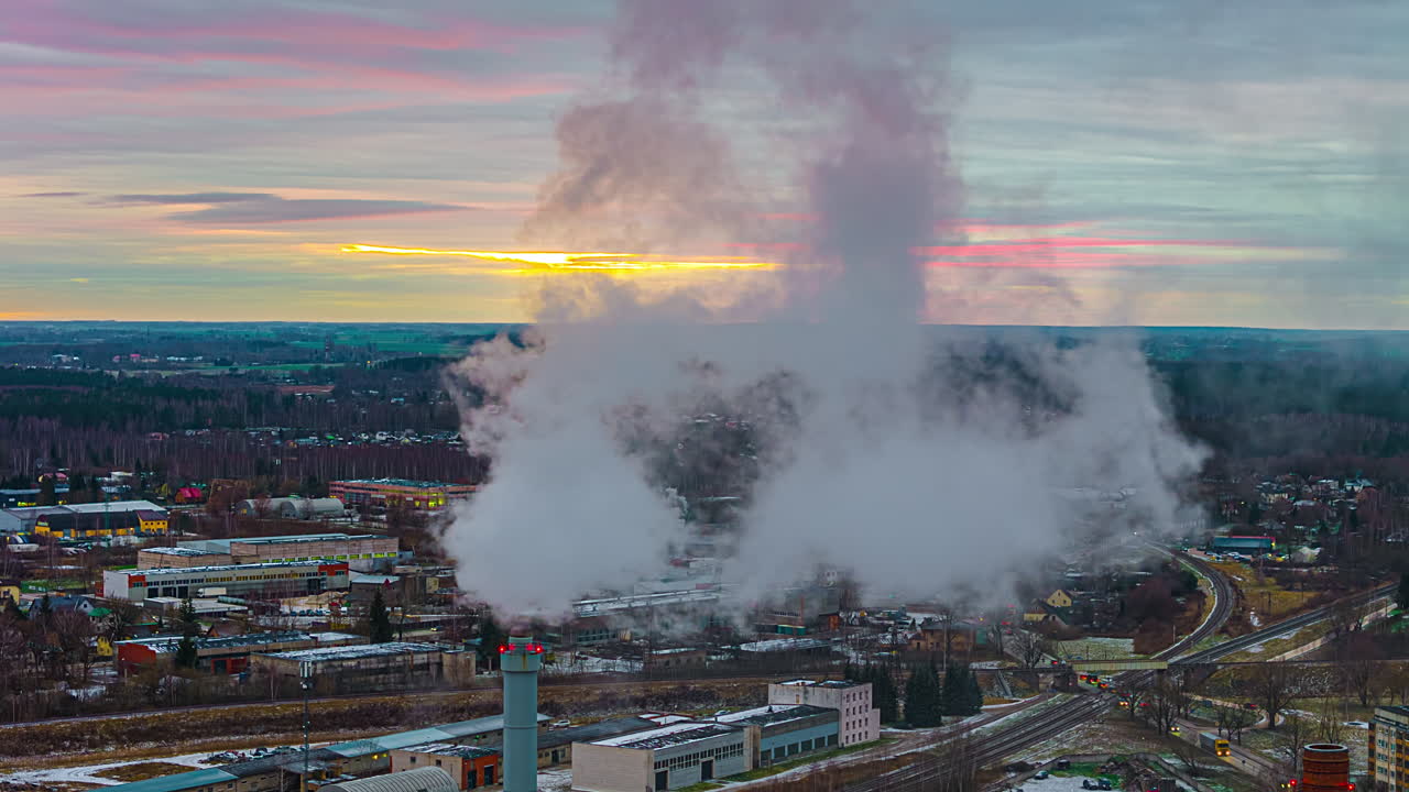 공중 하이퍼스 비행은 산업 도시 해가 지는 스카이 라인 위에서  굴 연기를 오염시니다.