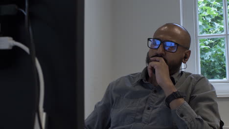 modern male office working swivelling on chair pensively looking at monitor