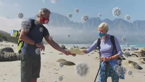 animation of covid 19 cells floating over senior couple wearing face masks with backpacks on beach